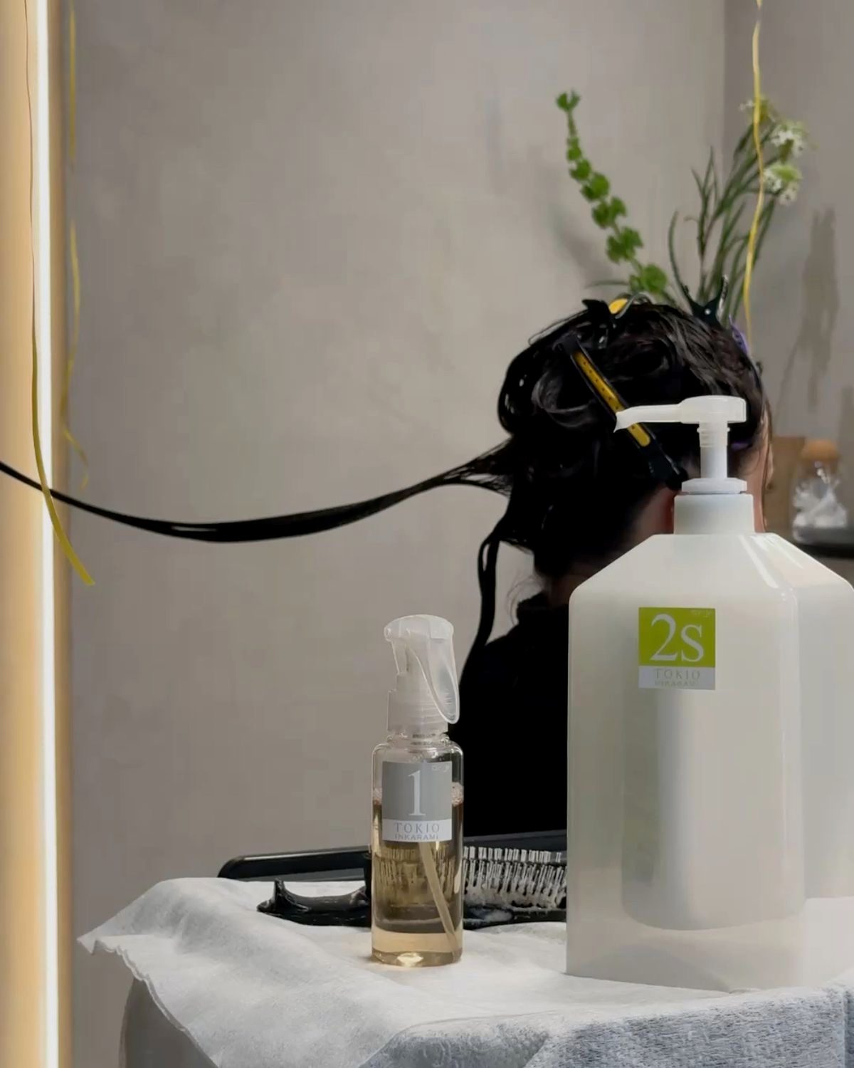 Tokio Inkarami treatment bottles beside a client having her hair treated at Blanche Beauty