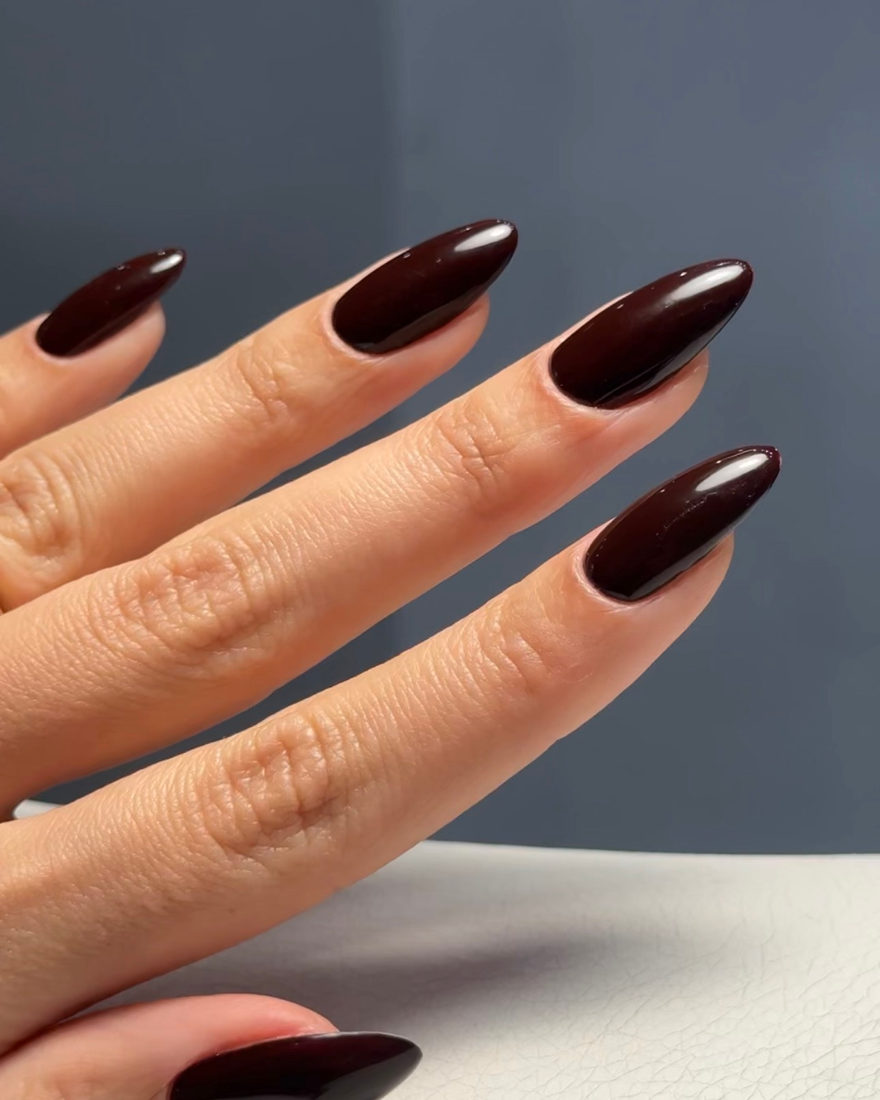 Almond nail extensions in dark burgundy at Blanche Beauty